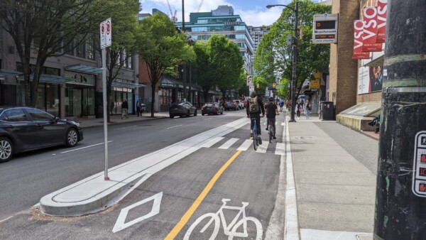 Verhoogde fietspad voor bereikbaar passagier laden en lossen naast een gemeentelijke theatre - ontworpen met hellen om geen rioleren te modificeren